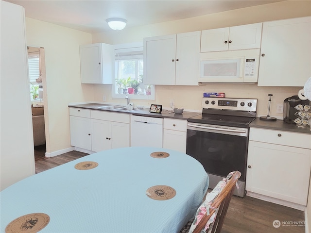 kitchen with sink, white appliances, dark wood-type flooring, and white cabinets