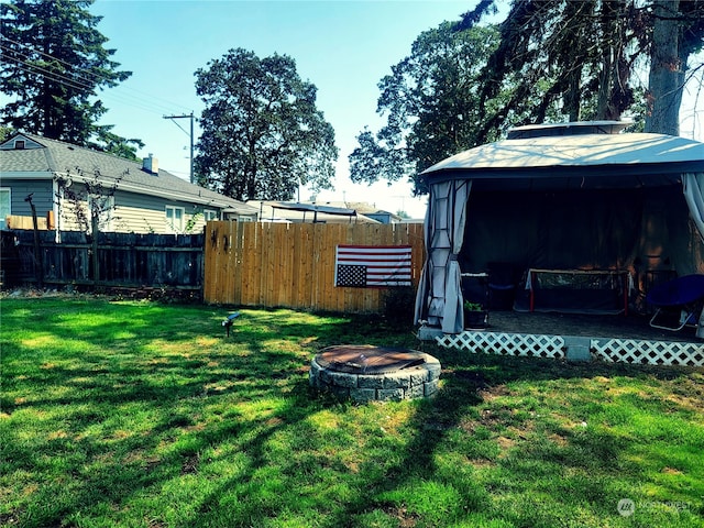 view of yard featuring a gazebo and a fire pit