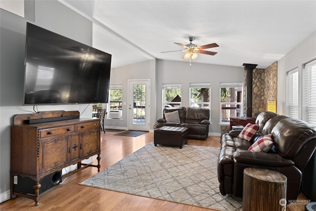 living room with a wealth of natural light, wood-type flooring, lofted ceiling with beams, and ceiling fan