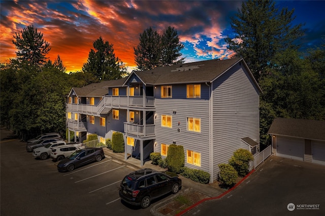 view of front of property with a garage, an outdoor structure, and a balcony