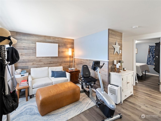 living room featuring light wood-type flooring and wood walls