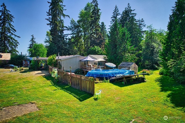 view of yard featuring a covered pool and a storage unit