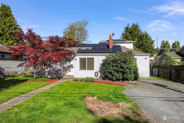 view of front of house featuring a front lawn and solar panels