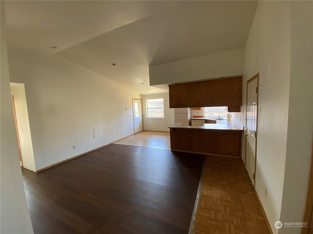 unfurnished living room featuring wood-type flooring and vaulted ceiling