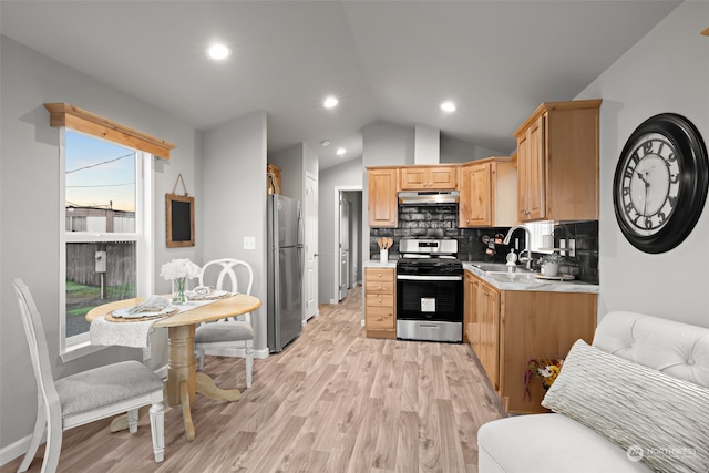 kitchen featuring lofted ceiling, backsplash, sink, light hardwood / wood-style flooring, and stainless steel appliances