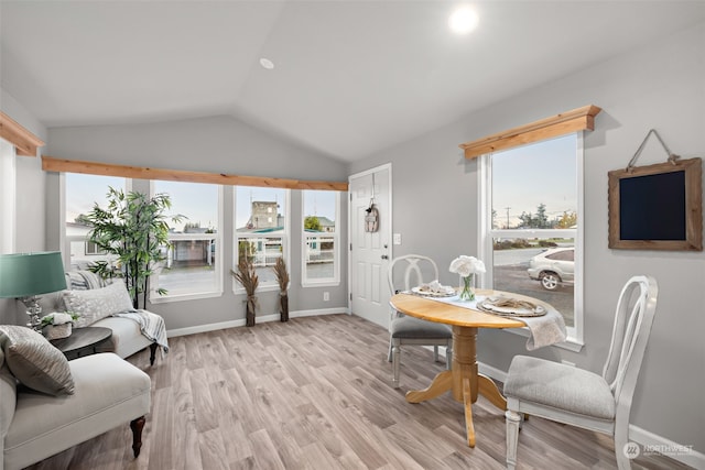 dining area featuring light hardwood / wood-style floors and vaulted ceiling