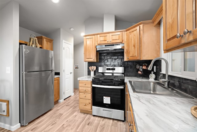 kitchen with lofted ceiling, sink, light hardwood / wood-style flooring, tasteful backsplash, and stainless steel appliances