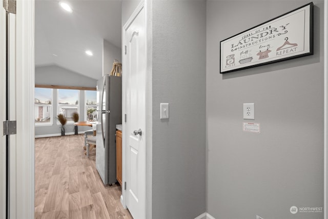 corridor featuring light hardwood / wood-style flooring and lofted ceiling