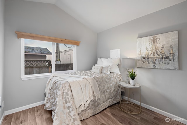 bedroom with hardwood / wood-style floors and vaulted ceiling