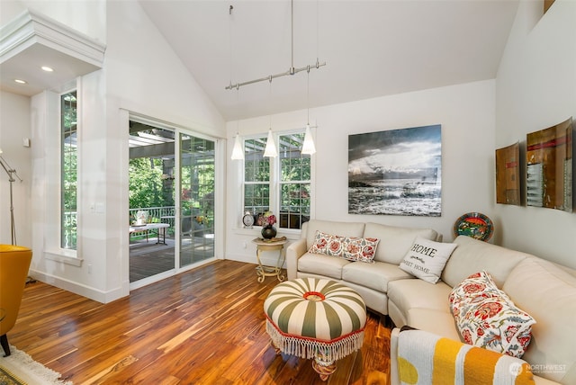 living area with vaulted ceiling, baseboards, and wood finished floors