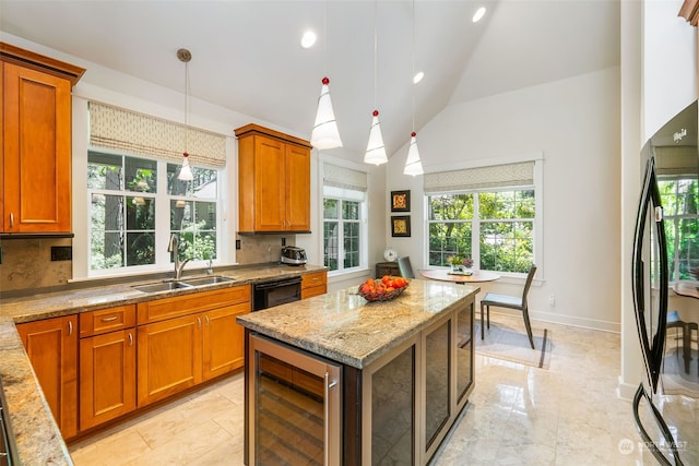 kitchen featuring wine cooler, brown cabinets, a sink, light stone countertops, and black appliances