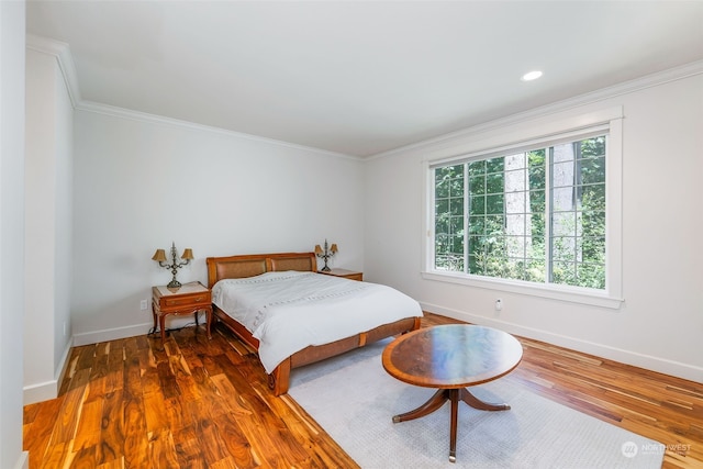 bedroom featuring multiple windows, baseboards, and wood finished floors