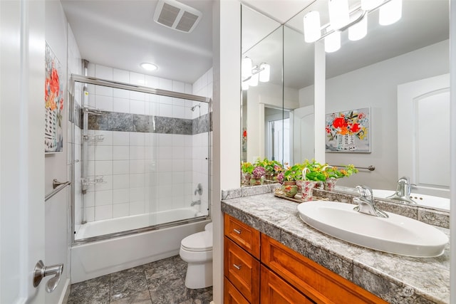 bathroom featuring toilet, bath / shower combo with glass door, vanity, and visible vents