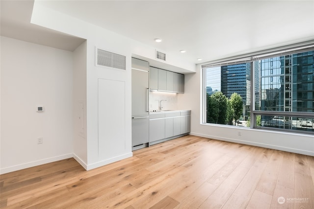 interior space featuring paneled refrigerator, sink, and light hardwood / wood-style floors