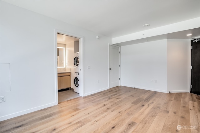 interior space with light hardwood / wood-style flooring and stacked washer and clothes dryer