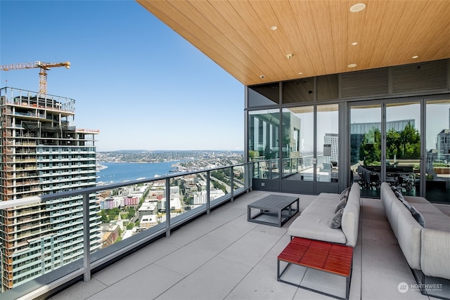 balcony featuring an outdoor living space and a water view