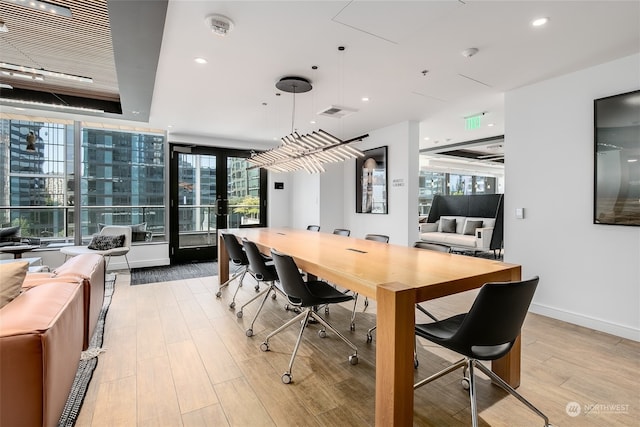 dining area featuring plenty of natural light, light wood-type flooring, and french doors