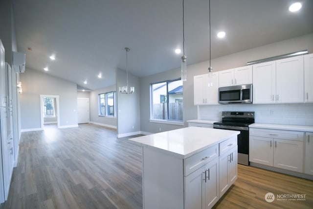 kitchen with white cabinetry, appliances with stainless steel finishes, vaulted ceiling, and backsplash