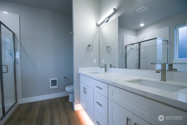 bathroom with wood-type flooring, toilet, vanity, and walk in shower