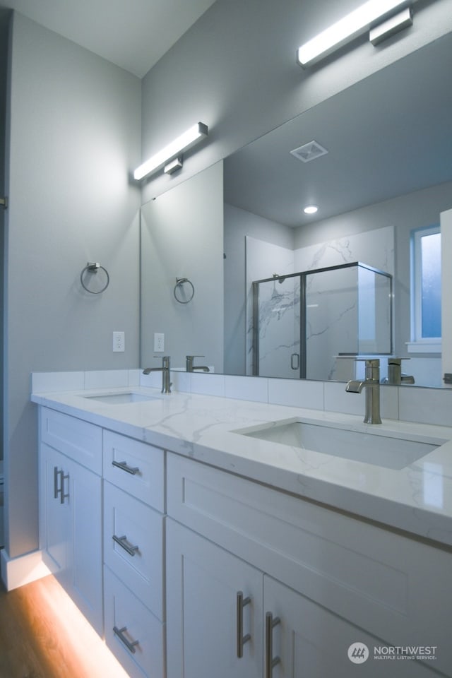 bathroom featuring hardwood / wood-style flooring, vanity, and walk in shower