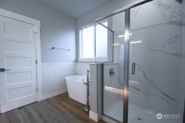 bathroom featuring wood-type flooring and separate shower and tub