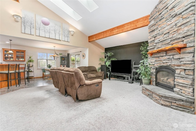 living room with carpet floors, vaulted ceiling with skylight, and a fireplace