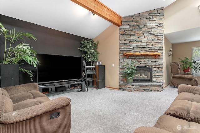 carpeted living room featuring a stone fireplace and vaulted ceiling with beams