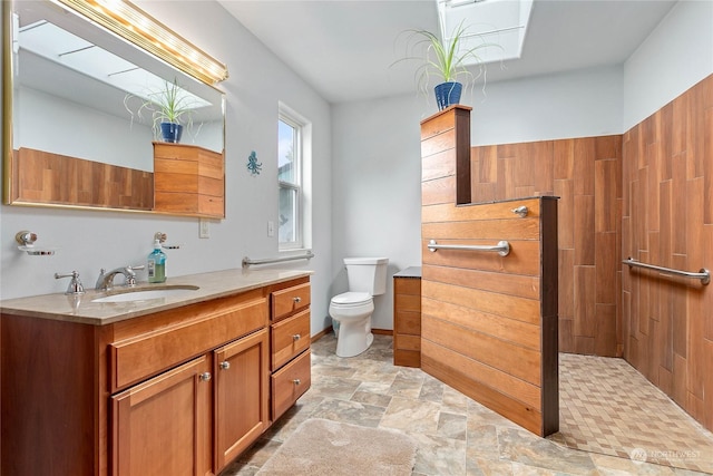 bathroom featuring vanity, walk in shower, and toilet