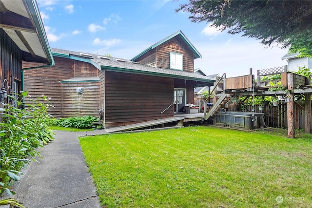 exterior space with a yard, a hot tub, and a deck