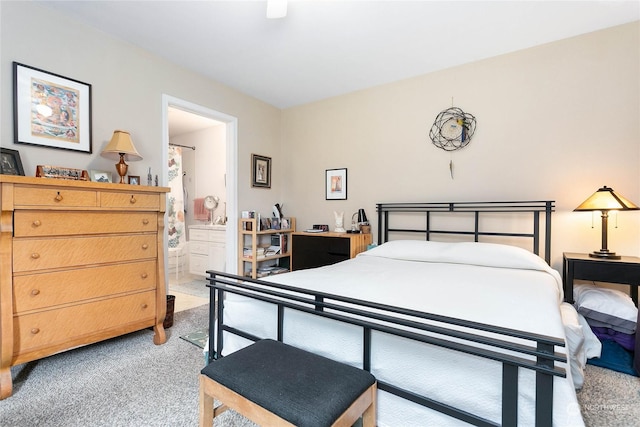 bedroom with light colored carpet, ceiling fan, and ensuite bathroom