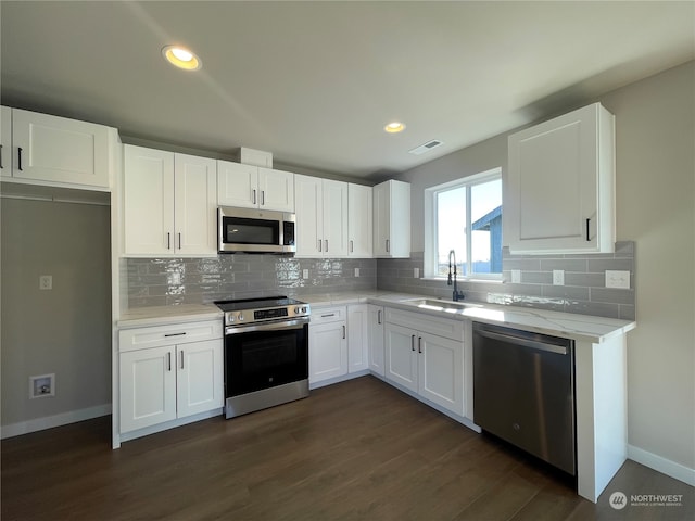 kitchen with white cabinets, dark wood-type flooring, and appliances with stainless steel finishes