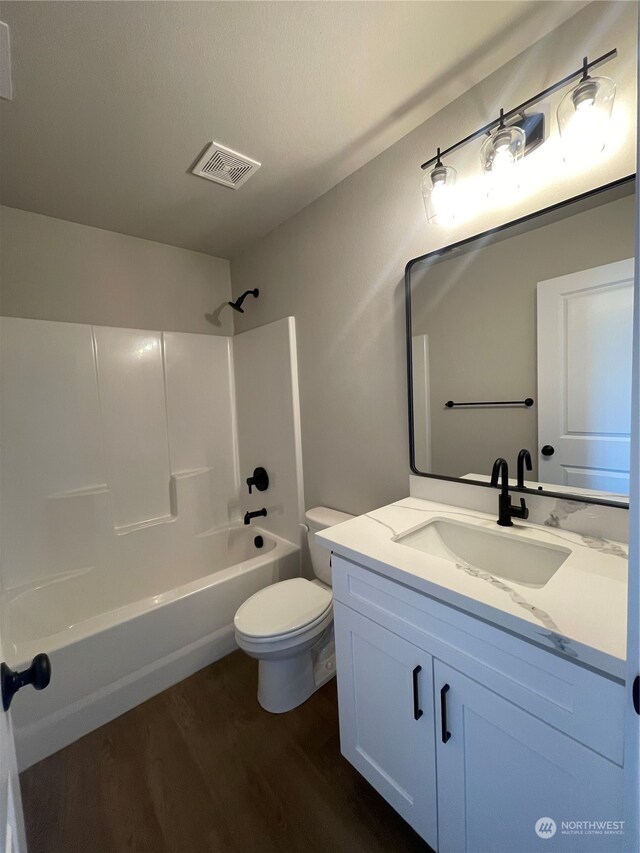 full bathroom featuring shower / tub combination, vanity, hardwood / wood-style flooring, and toilet