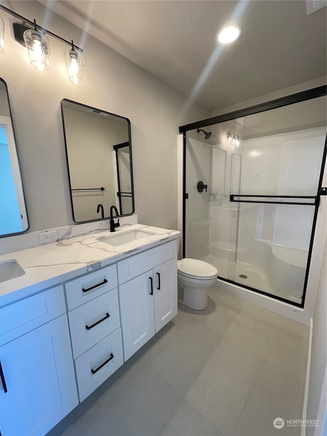 bathroom featuring vanity, toilet, and walk in shower