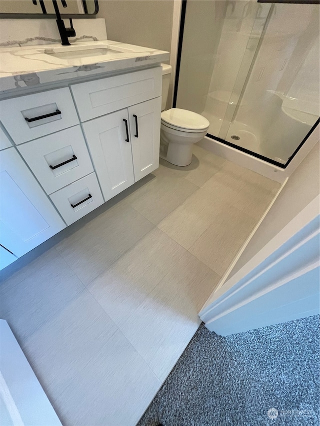 bathroom featuring vanity, toilet, and an enclosed shower