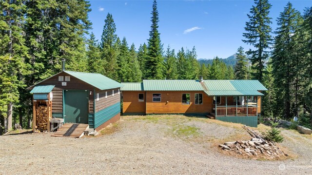 291 Spoke Ln, Cle Elum, WA 98922 - view of front facade featuring a view of trees, metal roof, and an outbuilding