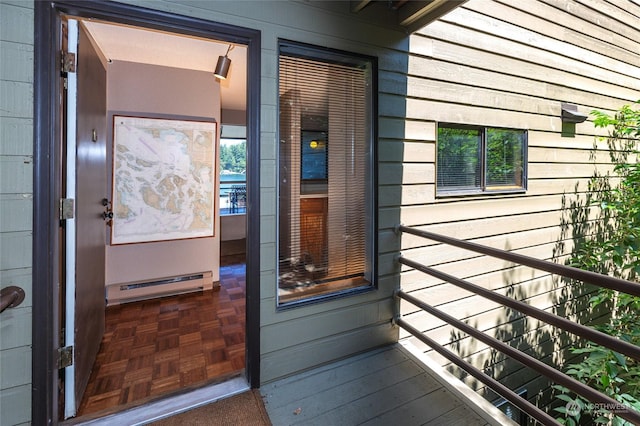 doorway to property with a balcony and a baseboard heating unit