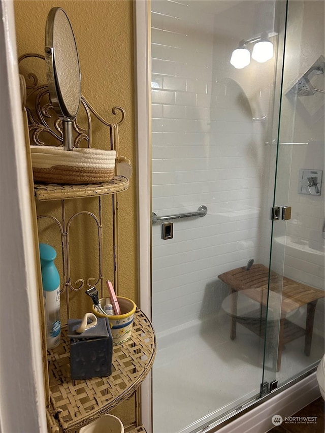 bathroom featuring a shower with shower door