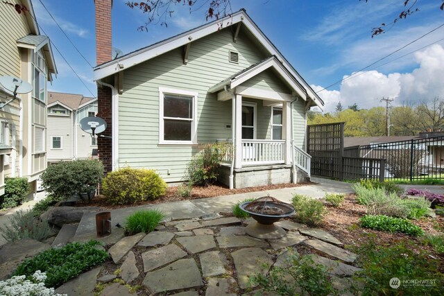 rear view of property featuring a fire pit