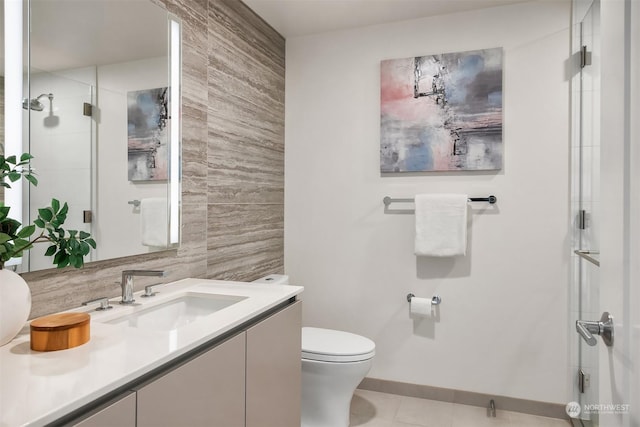 bathroom featuring tile patterned floors, toilet, a shower with shower door, vanity, and decorative backsplash