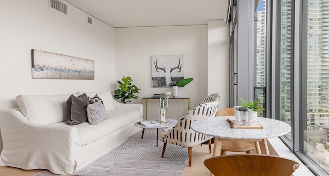 living room with hardwood / wood-style flooring, floor to ceiling windows, and a wealth of natural light