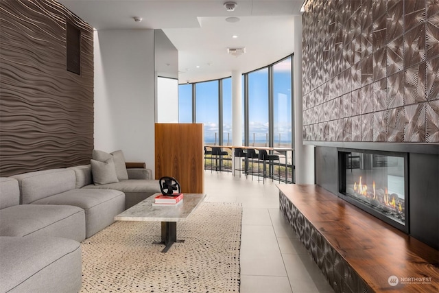 living room featuring light tile patterned floors, a fireplace, and expansive windows