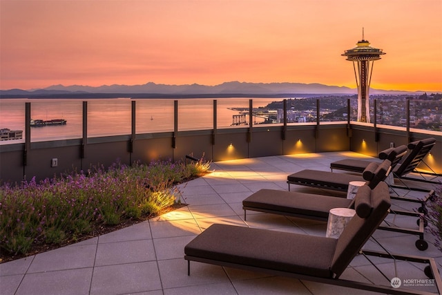 patio terrace at dusk with a water and mountain view