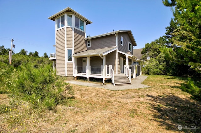 rear view of house with a lawn and a sunroom