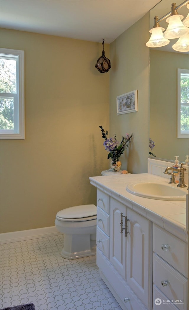 bathroom featuring tile patterned floors, vanity, toilet, and a healthy amount of sunlight