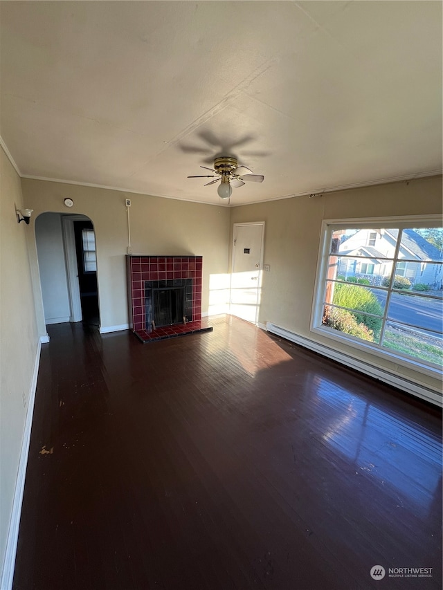 unfurnished living room featuring a baseboard heating unit, a tile fireplace, ceiling fan, and hardwood / wood-style floors