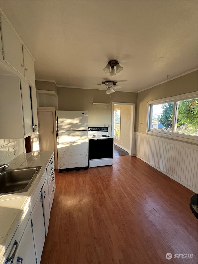 kitchen with hardwood / wood-style flooring, stainless steel fridge, white cabinetry, white electric range, and ceiling fan