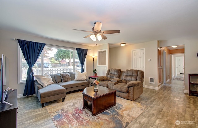 living room with light hardwood / wood-style floors and ceiling fan