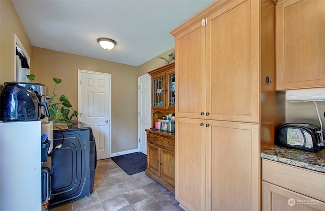 clothes washing area featuring light tile patterned flooring, separate washer and dryer, and cabinets