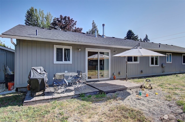 back of property featuring a deck and a yard