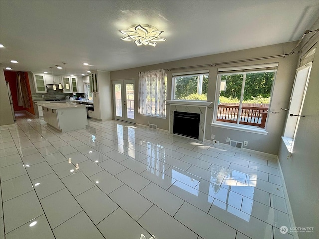 unfurnished living room featuring light tile patterned floors and french doors